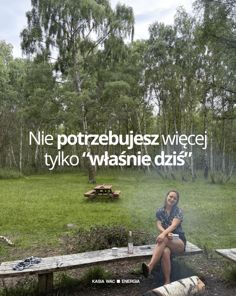 Kobieta siedząca przy jeziorze i ognisku z napisem „Nie potrzebujesz więcej, tylko właśnie dziś”, nawiązującym do Reiki i powrotu do siebie.
